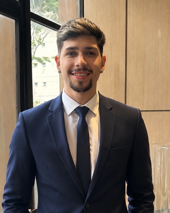 Lucas López de terno azul-marinho, sorrindo